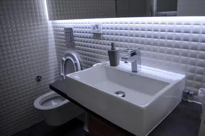 a white bathroom with a sink and a toilet at Apartments Good Night in Niš