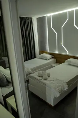 a hotel room with two beds and a mirror at Apartments Good Night in Niš