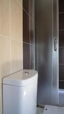 a bathroom with a toilet and a glass shower at Apartments Good Night in Niš