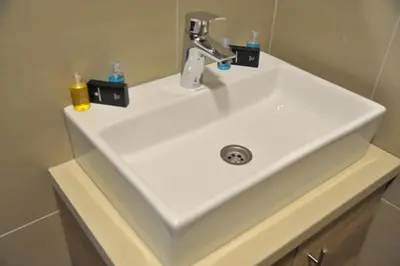 a white bathroom sink with two soap bottles on it at Apartments Milmari M 6.7.8 in Kopaonik
