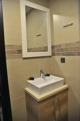 a bathroom with a white sink and a mirror at Apartments Milmari M 6.7.8 in Kopaonik