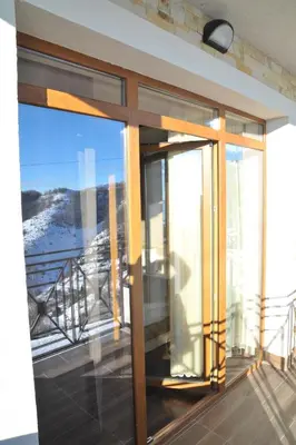 a glass door on a balcony with a view at Apartments Milmari M 6.7.8 in Kopaonik