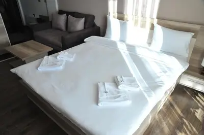 a large white bed with two towels on it at Apartments Milmari M 6.7.8 in Kopaonik