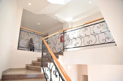 a person walking down a staircase with a wrought iron railing at Apartments Milmari M 6.7.8 in Kopaonik