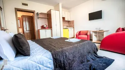 a bedroom with a bed and a red chair at Apartments Passage in Vrnjačka Banja