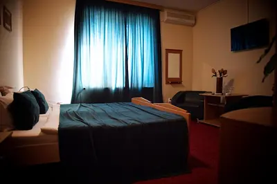 a hotel room with a bed and a blue curtain at Apartments Passage in Vrnjačka Banja