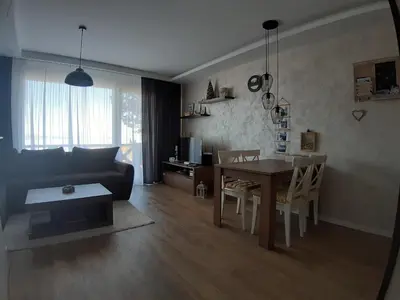 a living room with a black couch and a table at Apartman Dragana Kopaonik in Kopaonik