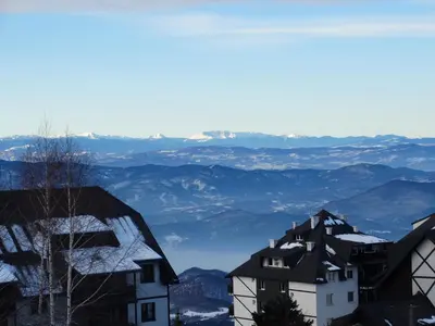 a view of mountains and houses in the snow at Apartman Dragana Kopaonik in Kopaonik