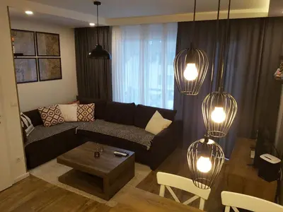 a living room with a couch and a table and lights at Apartman Dragana Kopaonik in Kopaonik