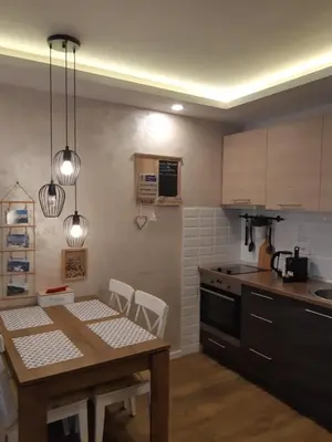 a kitchen with a wooden table and a dining room at Apartman Dragana Kopaonik in Kopaonik