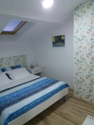 a bedroom with a large bed in a room at Stan Na Dan in Niš