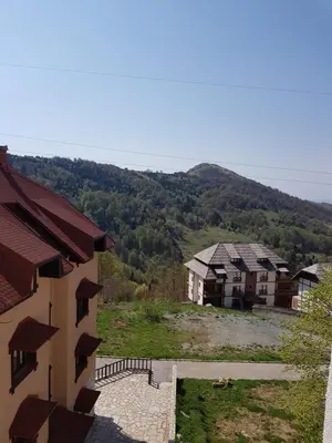 a view of a group of houses with mountains in the background at SkiTime Apartment in Kopaonik