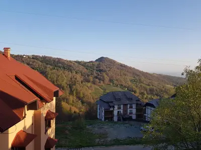 a view of a house with a mountain in the background at SkiTime Apartment in Kopaonik