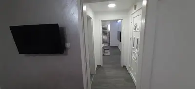 a hallway with a flat screen tv on a wall at Adrijana 1 Apartmani in Vrnjačka Banja