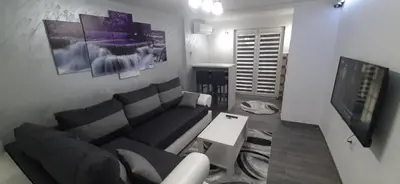 a living room with a couch and a flat screen tv at Adrijana 1 Apartmani in Vrnjačka Banja