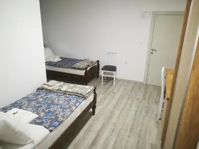 a room with two beds and a chair in it at Karavan 123 in Raška
