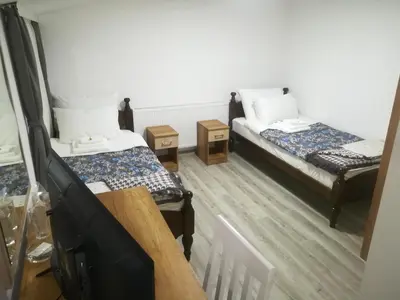 a room with two beds and a flat screen tv at Karavan 123 in Raška
