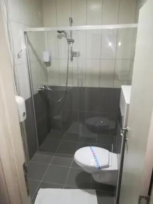 a bathroom with a shower with a toilet and a sink at Karavan 123 in Raška