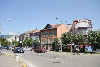 a busy city street with cars and a person riding a bike at City Center Apartments in Pirot