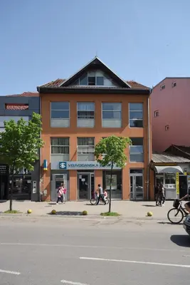 a group of people riding bikes in front of a building at City Center Apartments in Pirot