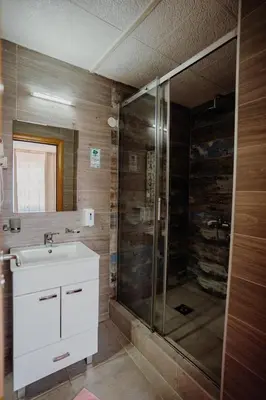 a bathroom with a glass shower and a sink at Gros Hotel - Leskovac in Leskovac