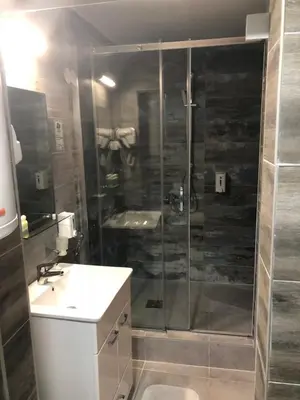 a bathroom with a shower and a sink at Gros Hotel - Leskovac in Leskovac