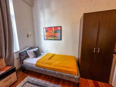 a small bedroom with a bed and a cabinet at The Only One Apartments in Niš