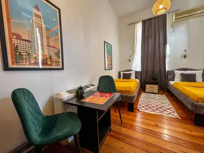 a bedroom with a bed and a desk and chairs at The Only One Apartments in Niš