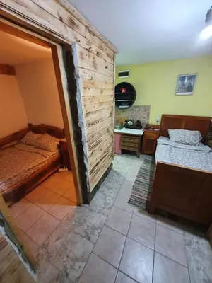 a bedroom with two beds in a room with a wall at Smeštaj 