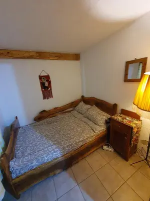 a bedroom with a wooden bed and a table at Smeštaj 