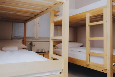 a bedroom with two bunk beds with white sheets at Bloom Inn in Niš