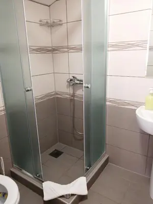 a shower with a glass door in a bathroom at Bloom Inn in Niš