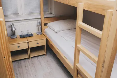 a bedroom with a bunk bed with a nightstand and a bed sidx sidx sidx at Bloom Inn in Niš