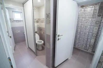 a bathroom with a toilet and a shower stall at Bloom Inn in Niš