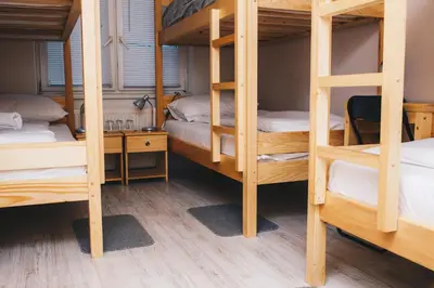 a room with four bunk beds and a desk at Bloom Inn in Niš