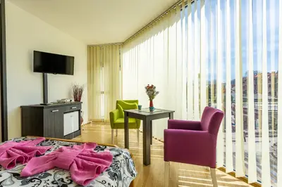 a hotel room with a bed and two chairs at Guesthouse Sunny in Soko Banja