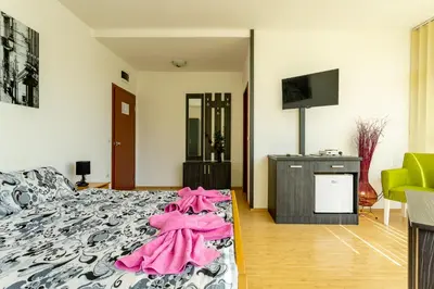 a bedroom with a bed with pink clothes on it at Guesthouse Sunny in Soko Banja