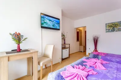 a room with a purple bed with pink towels on it at Guesthouse Sunny in Soko Banja