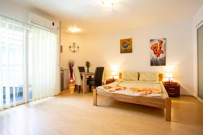 a bedroom with a bed and a dining room at Guesthouse Sunny in Soko Banja