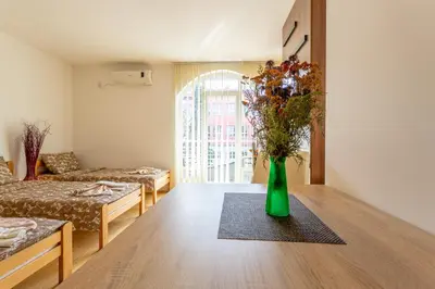 a living room with a green vase with flowers on a table at Guesthouse Sunny in Soko Banja