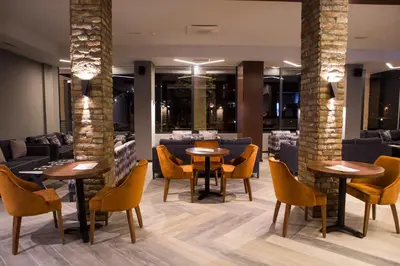 a restaurant with tables and chairs and a bar at A Hoteli - Hotel Slatina in Vrnjačka Banja