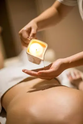 a woman getting her belly pierced with a candle at A Hoteli - Hotel Slatina in Vrnjačka Banja