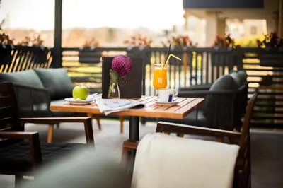 a table with a vase of flowers on it at A Hoteli - Hotel Slatina in Vrnjačka Banja