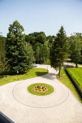 a circular walkway in a park with a garden at A Hoteli - Hotel Slatina in Vrnjačka Banja