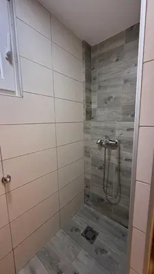 a shower with a glass door in a bathroom at Konak Garavi sokak in Kuršumlija