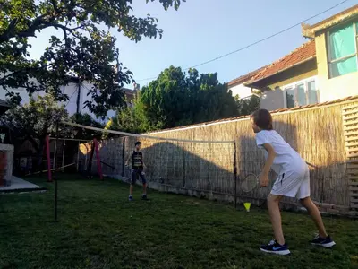 two young children playing a game of volleyball in a yard at Konak Garavi sokak in Kuršumlija