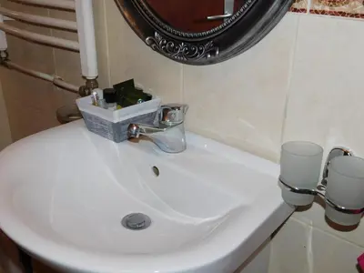 a bathroom sink with a mirror and two cups on it at Velvet Lux in Niš