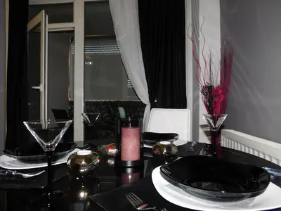 a dining room table with a black table cloth and glasses at Velvet Lux in Niš