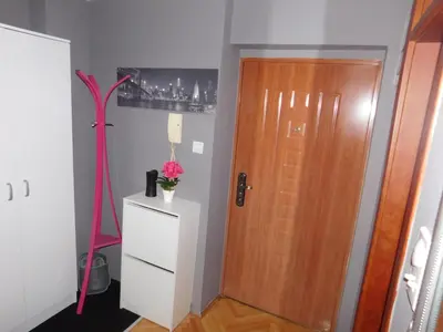 a room with a wooden door and a white cabinet at Velvet Lux in Niš