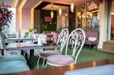 a table and chairs in a restaurant with tables and chairs at Garni Hotel Lotos in Niš